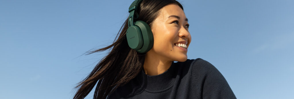 Girl smiling as she listens to something on the new Fairbuds XL